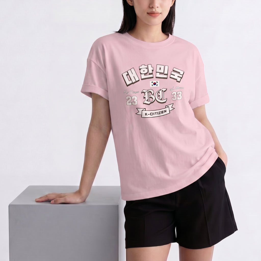 Person wearing a pink t-shirt with a pink K-citizen t-shirt featuring a varsity-style "대한민국" (Daehanminguk) design on a white background
