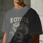 Person wearing a gray t-shirt with 'K-Citizen' and dragon design.