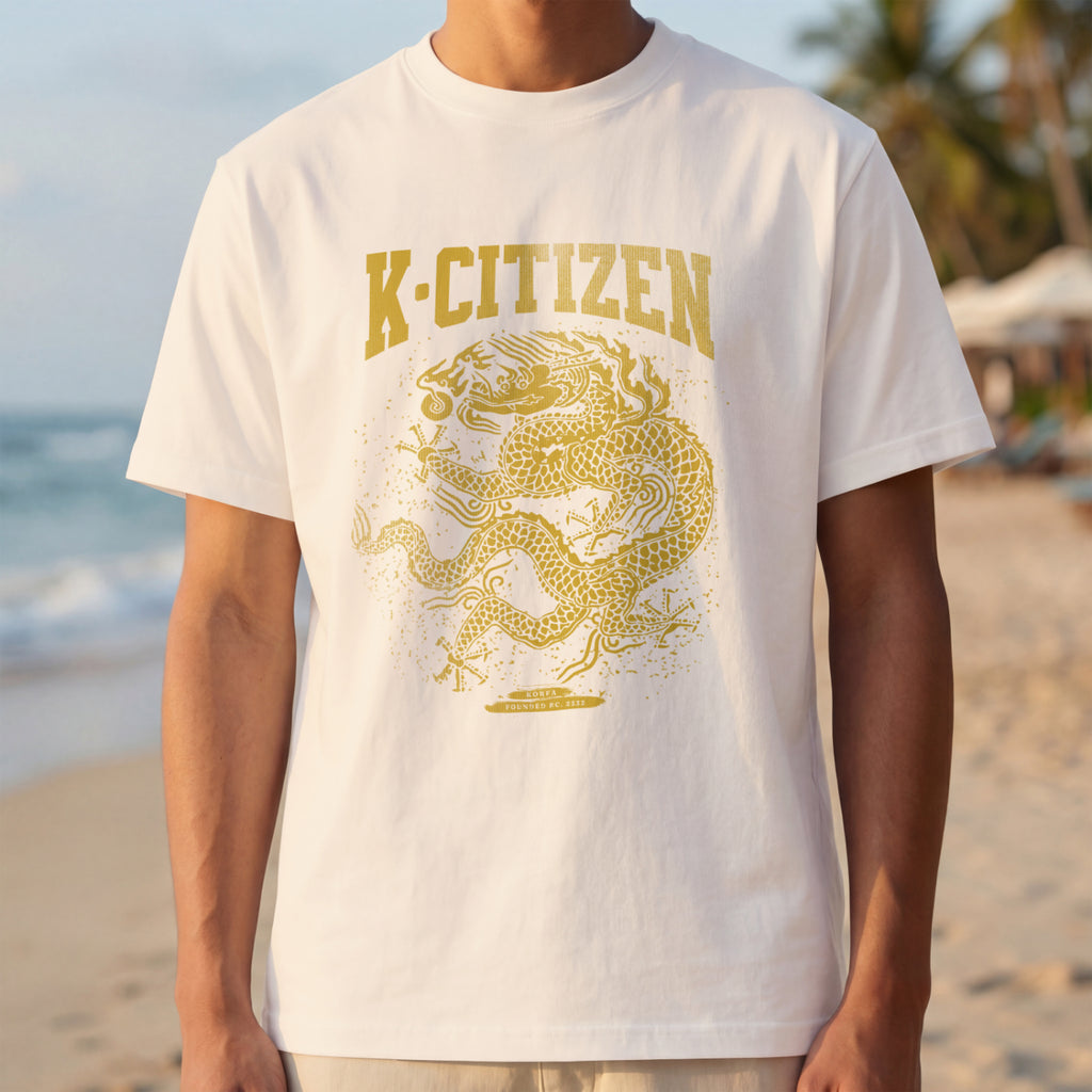 Person wearing a white t-shirt with a gold dragon design and 'K-Citizen' text on a beach.
