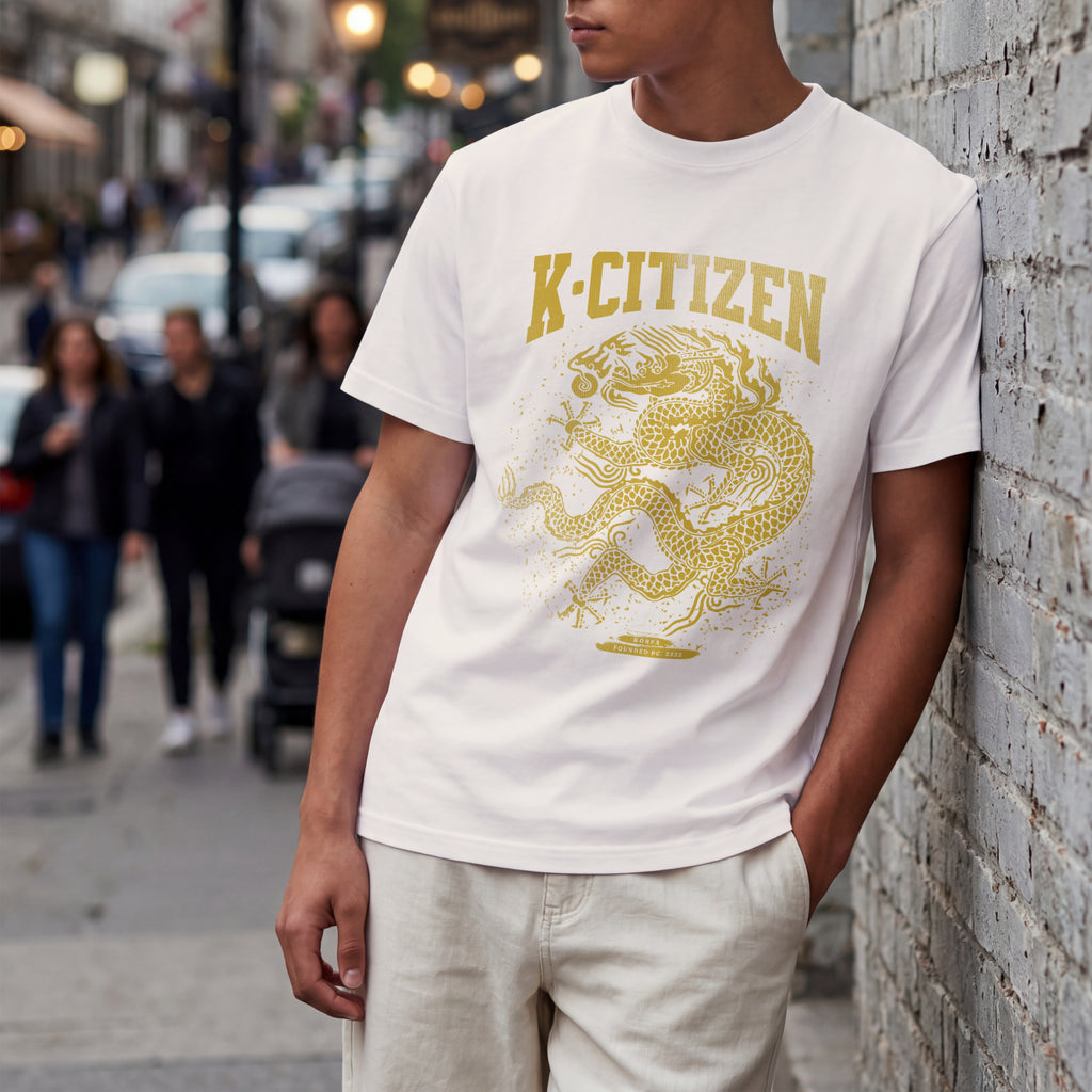 Person wearing a off white t-shirt with a Golden korean dragon graphic and 'K-Citizen' text on a city street.