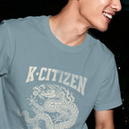 Person wearing a blue t-shirt with 'K-Citizen' and a korean dragon design in club at night