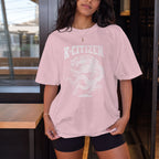 Person wearing a pink 'K-Citizen' t-shirt with a dragon design indoors.