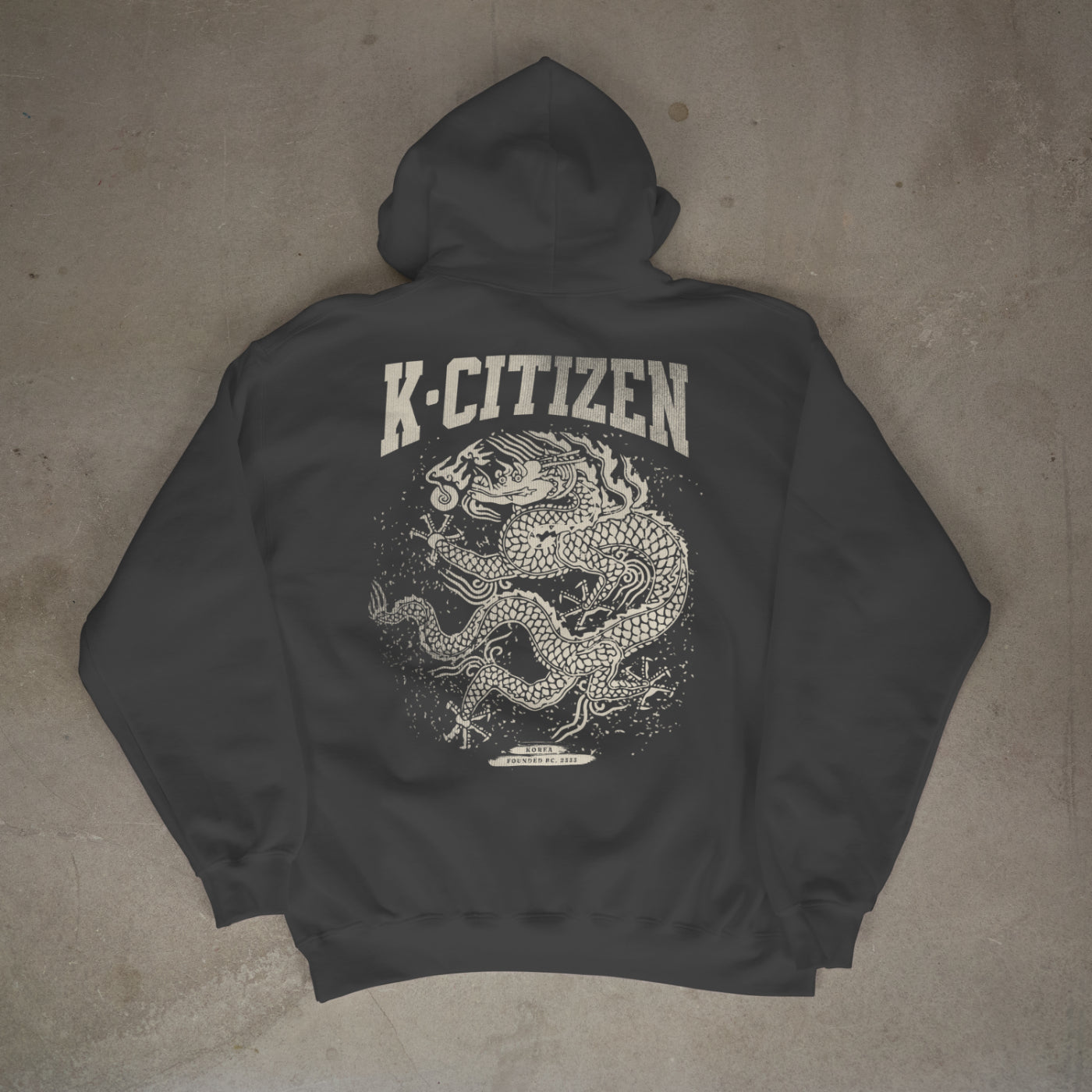 Dark gray hoodie with 'K-Citizen' logo and dragon design on a concrete floor.