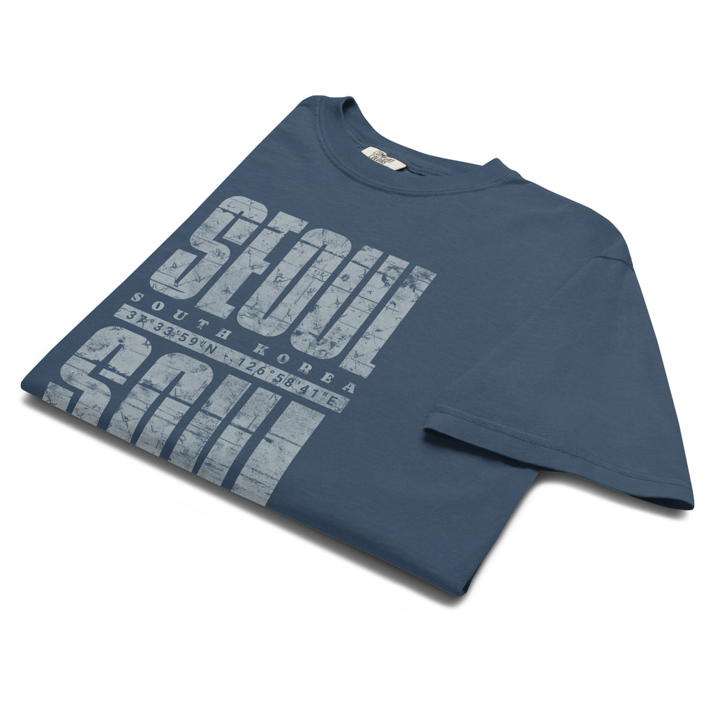close-up of Blue t-shirt featuring a distressed white "SEOUL SOUL" graphic with South Korea geographic coordinates