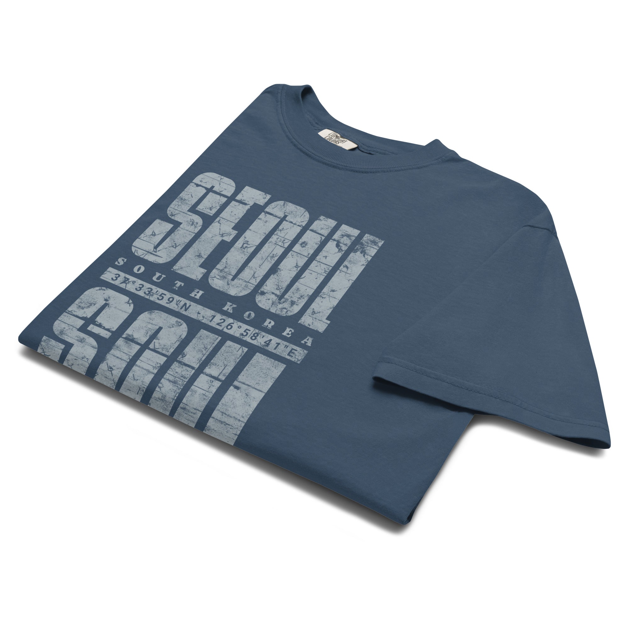 close-up of Blue t-shirt featuring a distressed white "SEOUL SOUL" graphic with South Korea geographic coordinates